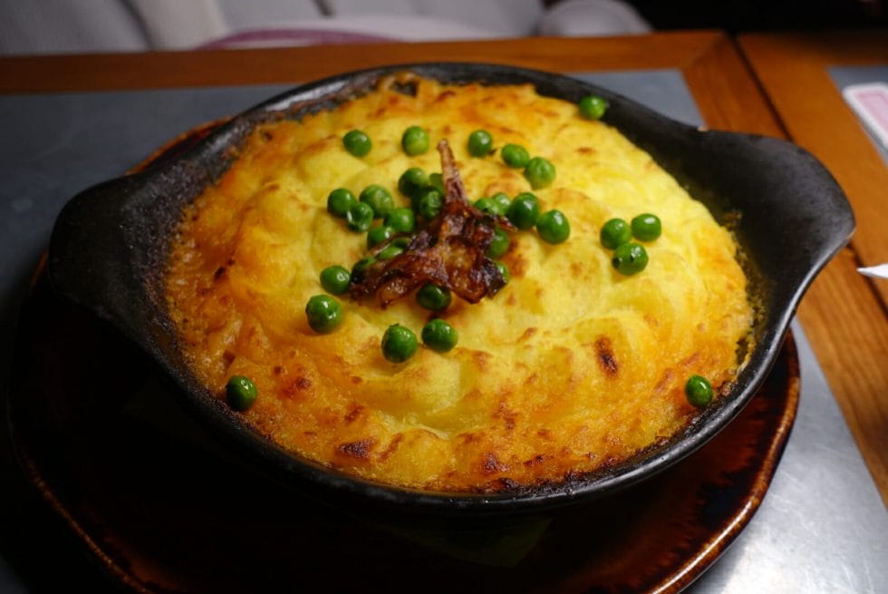 Dish of shepherds pie with mash and peas on top