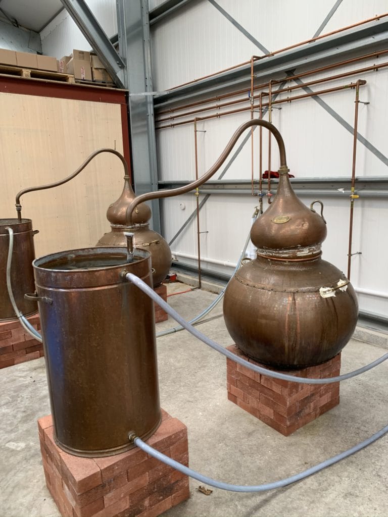 The copper gin stills sitting on bricks covering the paella cooking rings