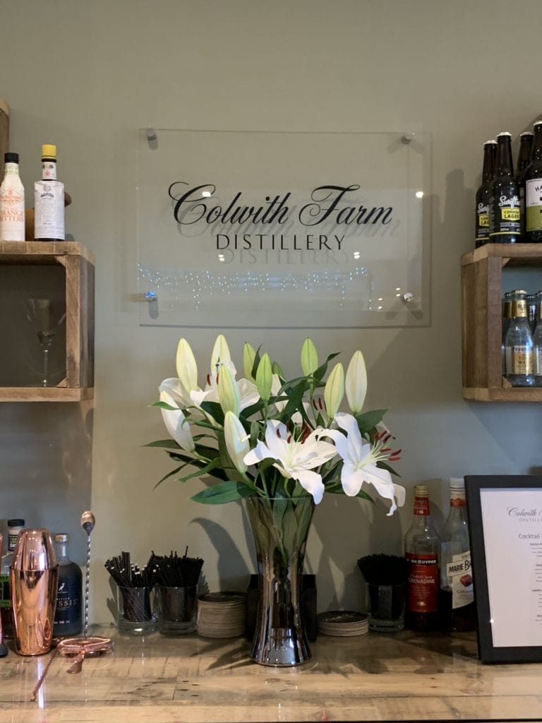 The bar area with lillies at Colwith Farm Distillery