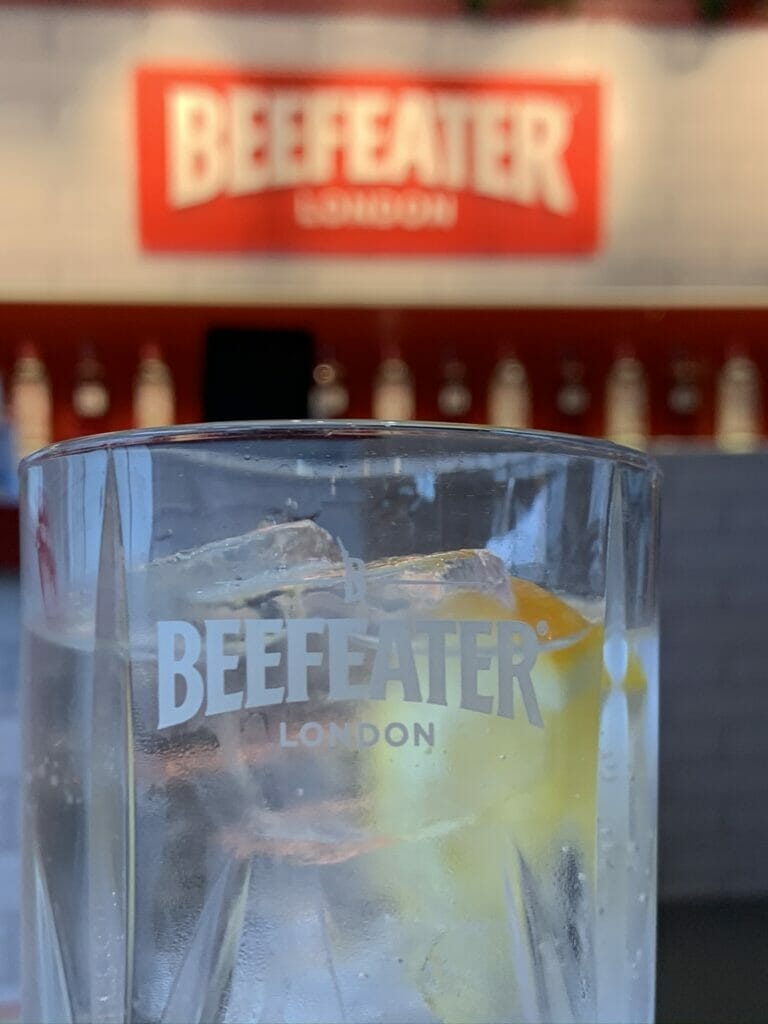 Beefeater gin glass in front of the Beefeater sign