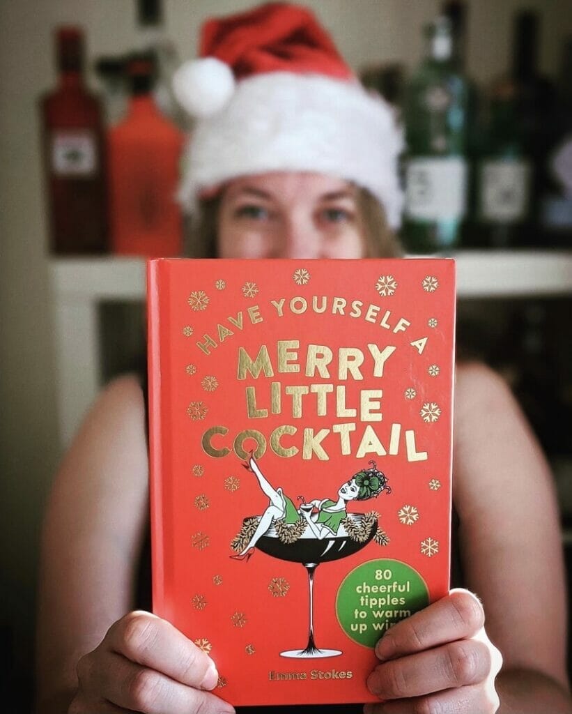 Have yourself a Merry Little Christmas cocktail book held by Emma Stokes