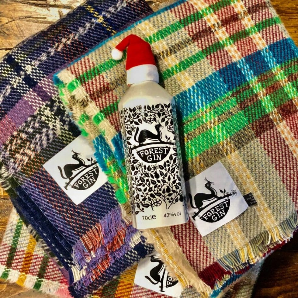 Forest gin bottle with a mini Santa hat on top of the gin blankets