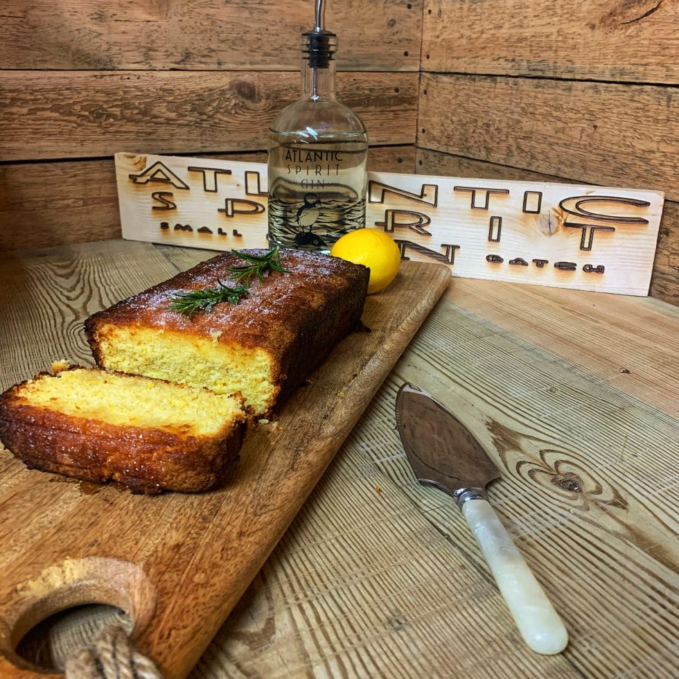 Clotted cream cake on a board with bottle of gin behind