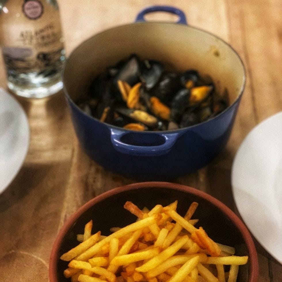 Bowls of mussels and fries with Atlantic Spirits Thai basil gin bottle