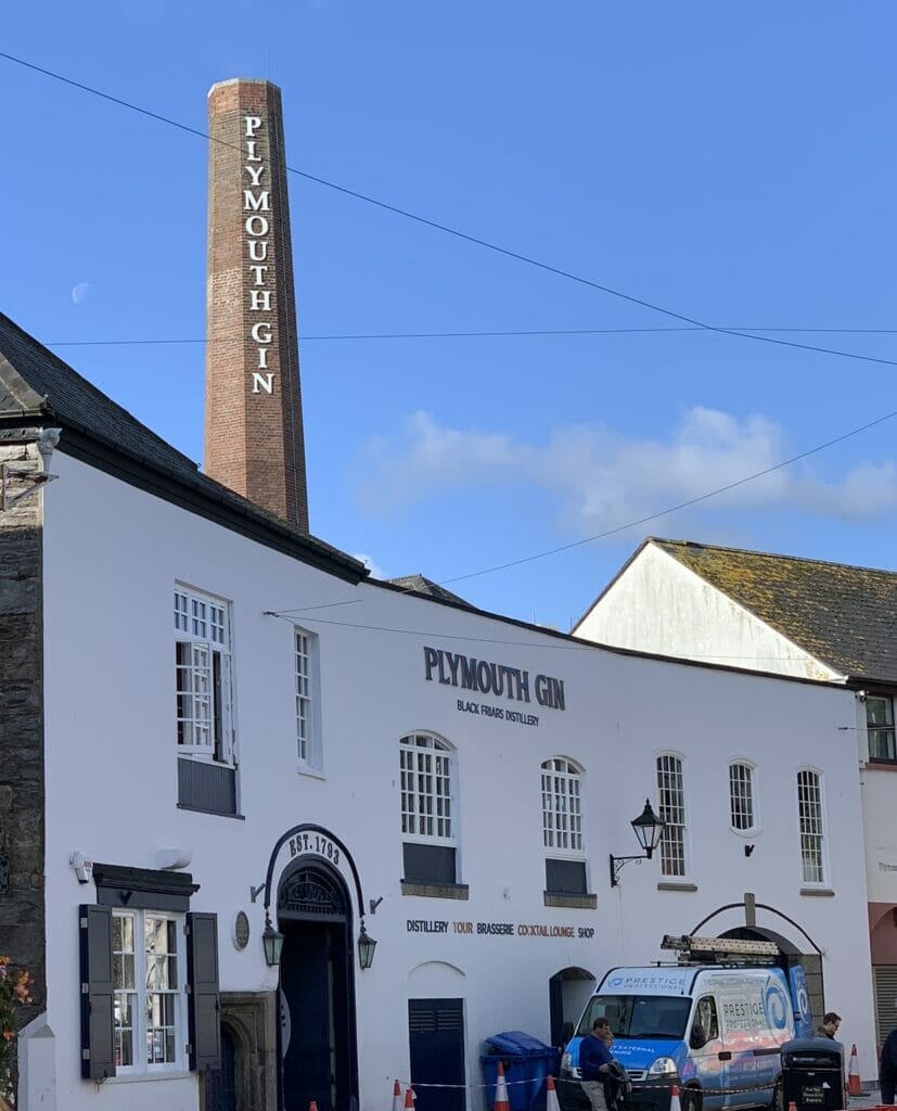 The outside of the distillery on the curve of the road with chimney