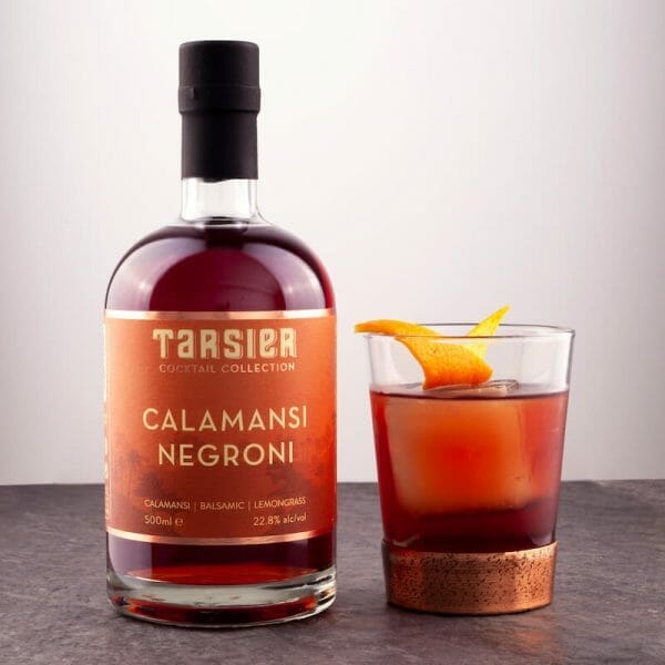 Calamansi negroni in glass next to cocktail in the bottle
