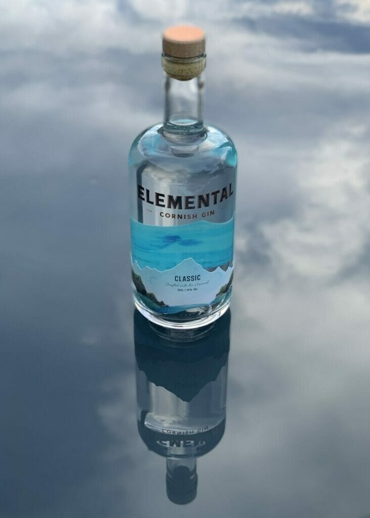 Elemental Cornish Dry gin bottle on table reflecting the sky