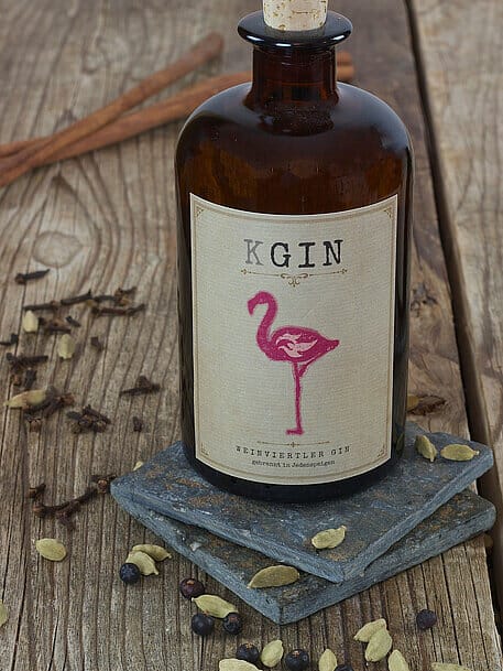 Brown bottle with pink flamingo on the label, surrounded by a scattering of botanicals